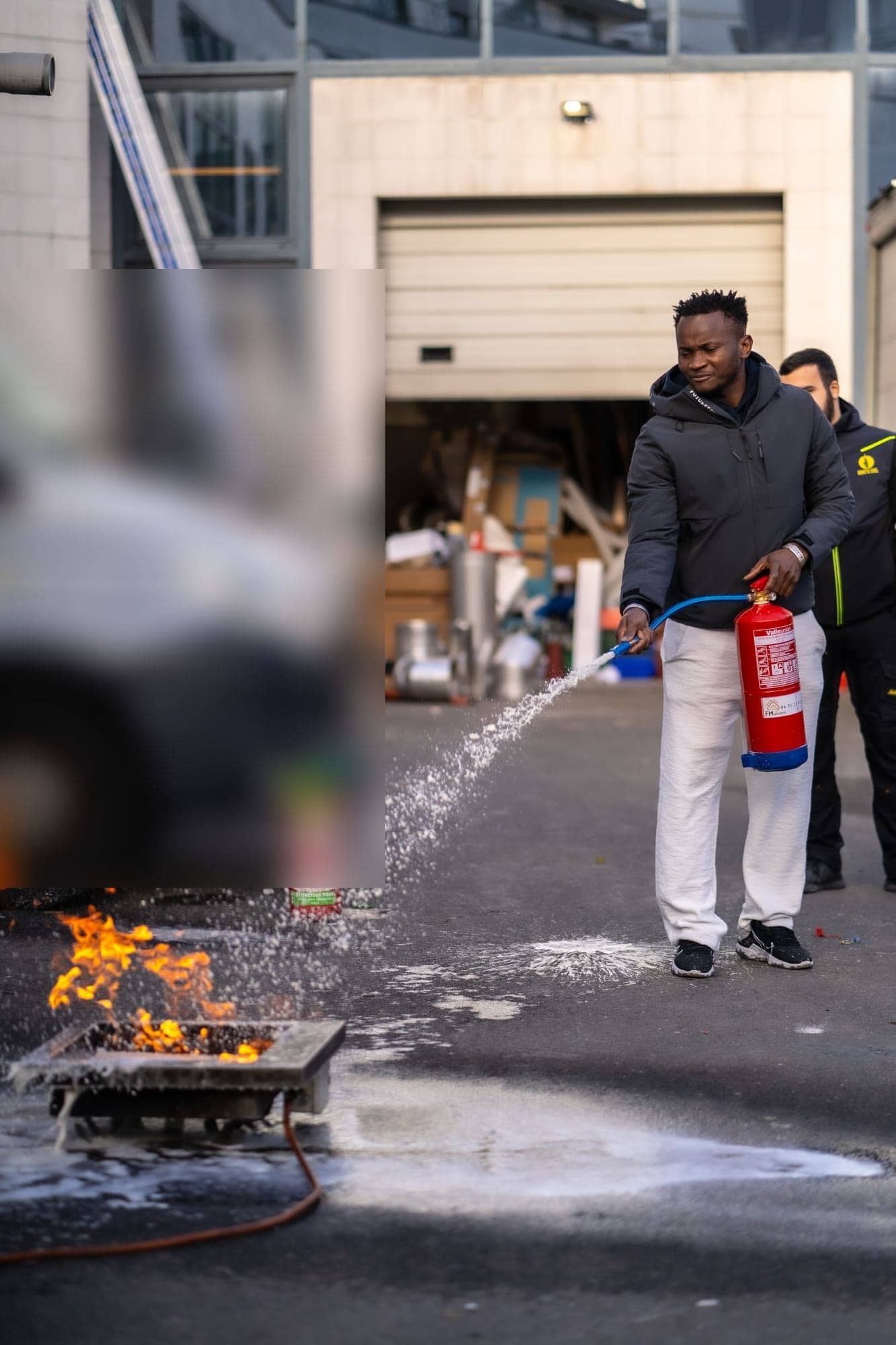 Exercice pratique d'extinction : stagiaire attaquant un feu de bac avec un extincteur à eau