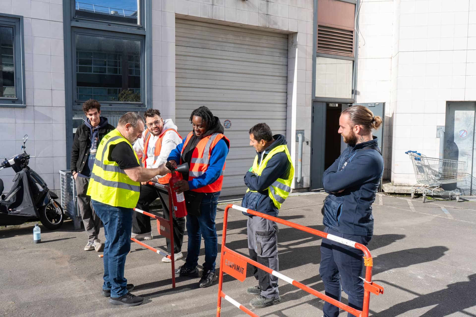 Formateur expliquant la prise en main d'un extincteur à un groupe de stagiaires