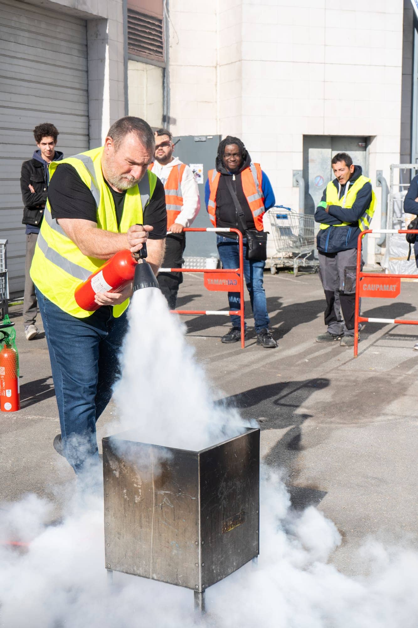 Formateur RCB déclenchant un extincteur CO2 sur un bac à feu pendant une formation incendie