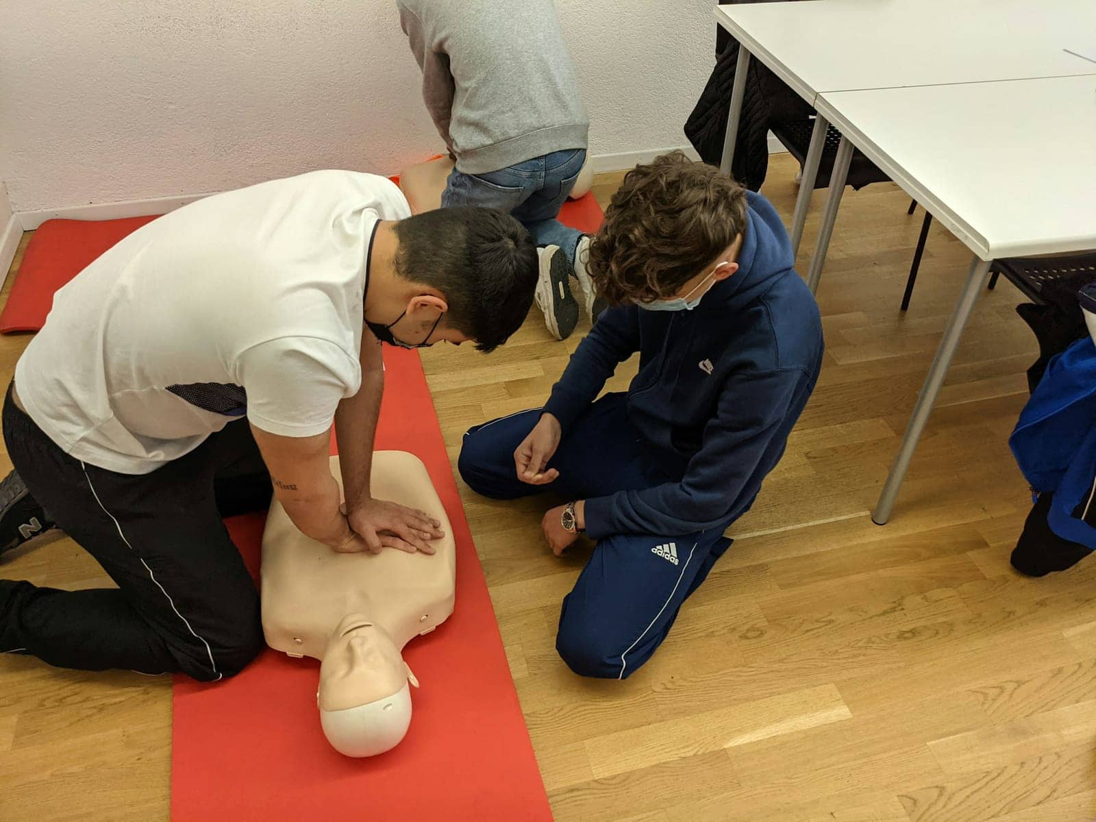 Stagiaire pratiquant un massage cardiaque sur un mannequin pendant une formation SST