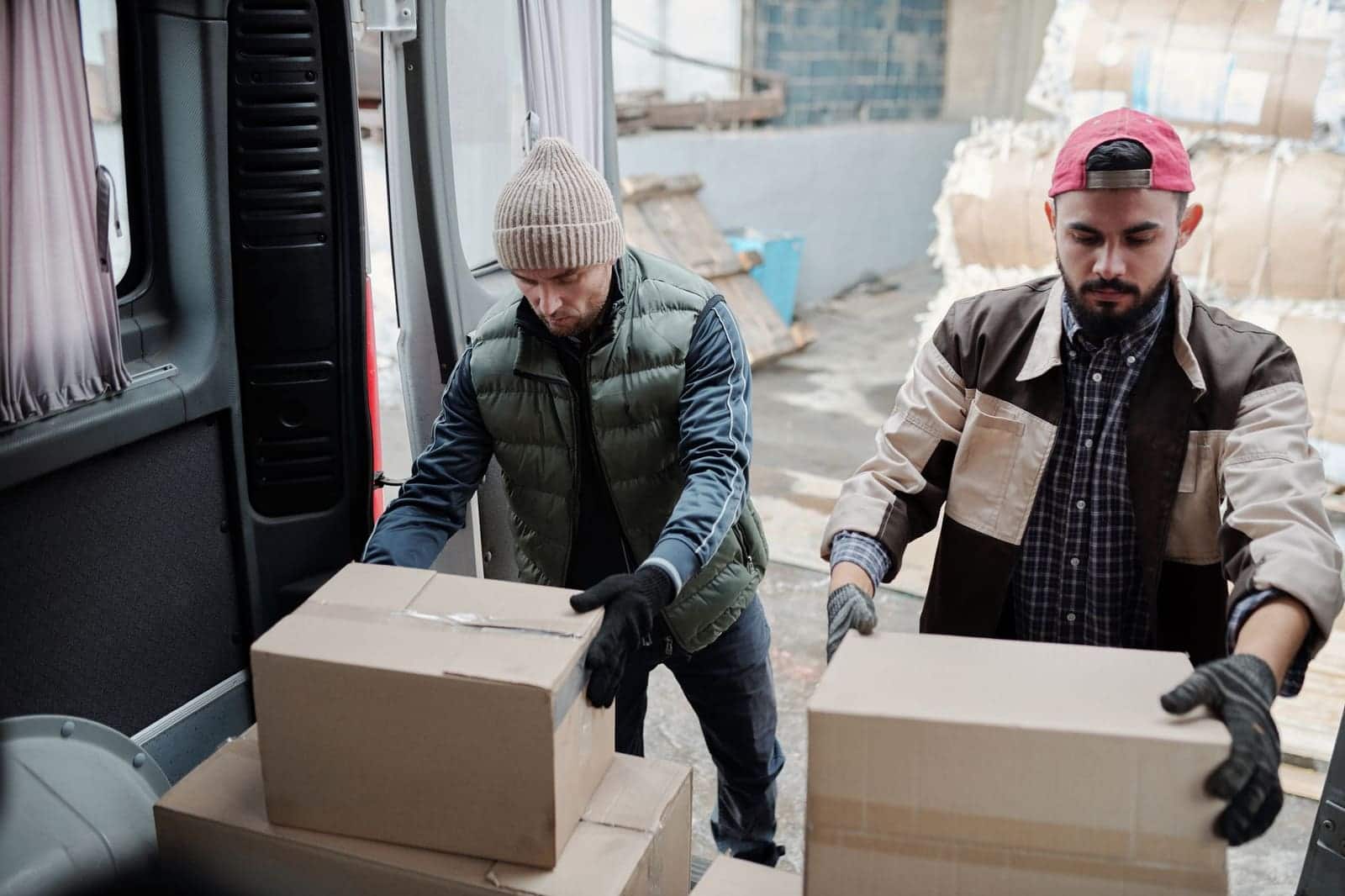Salariés soulevant des cartons en pliant les jambes, gestes de manutention