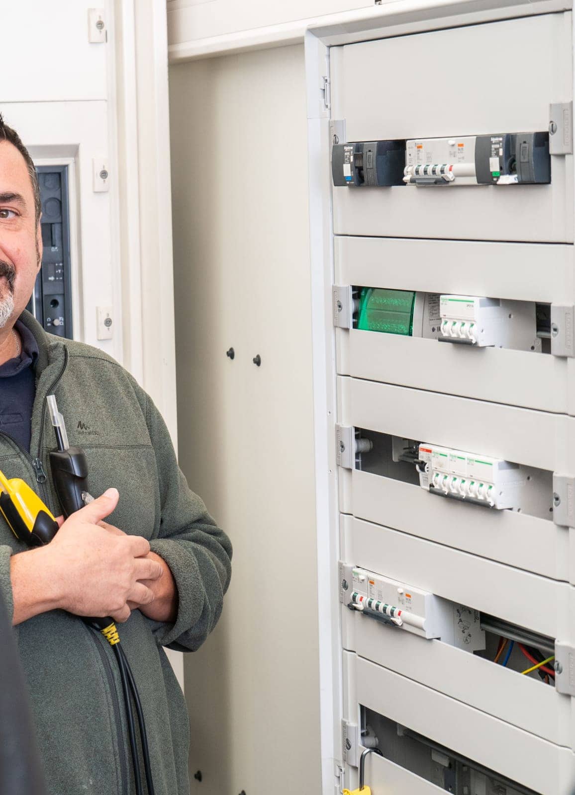 Formateur devant une armoire électrique ouverte, appareillages et borniers visibles