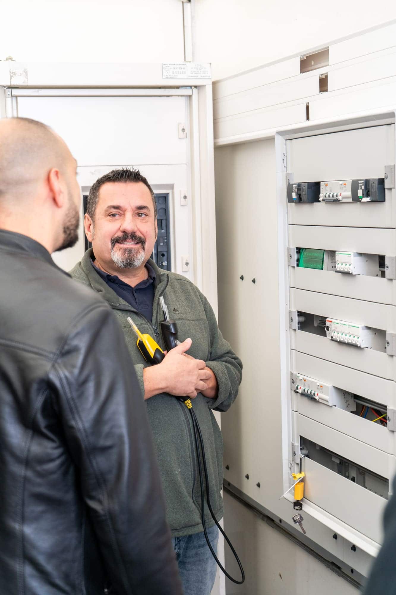 Formateur habilitation électrique devant une armoire électrique, en séance pratique