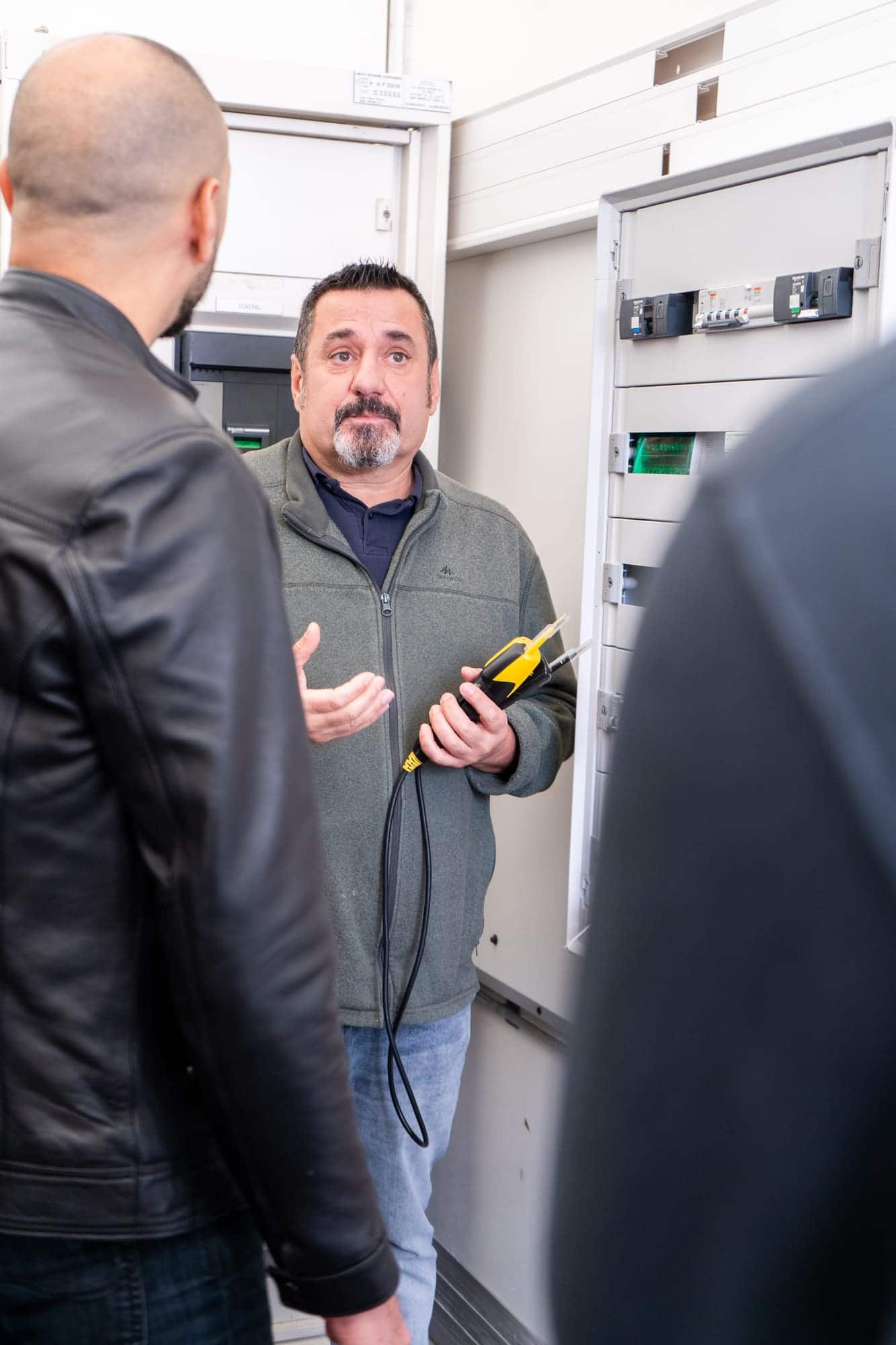 Formateur expliquant les règles de sécurité électrique, appareil de mesure en main